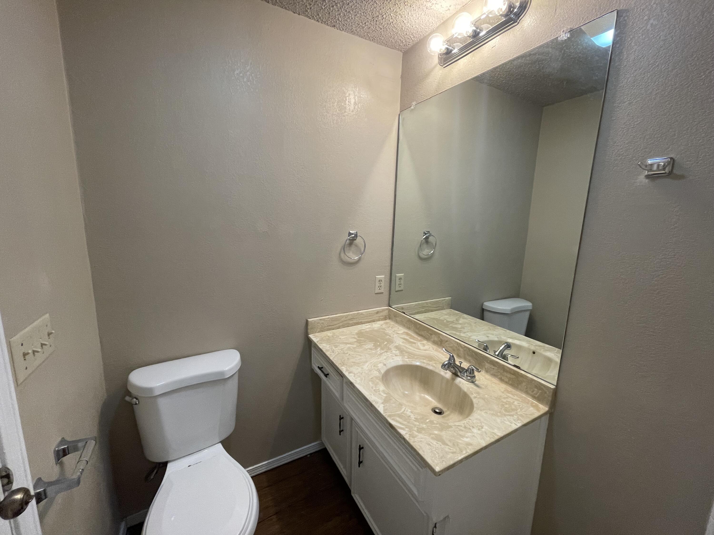 4413 75th Drive, Unit B Lubbock, TX 79424 - Photo 8 of 9 a bathroom with a toilet sink and mirror