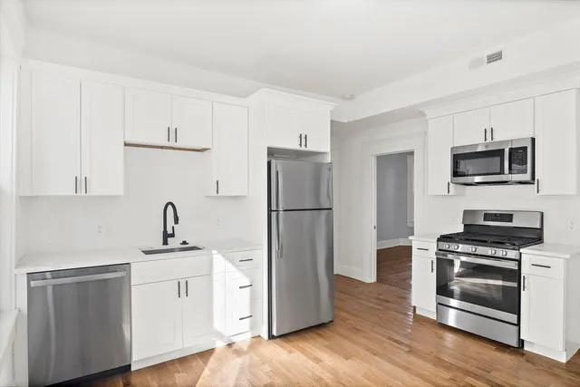 a kitchen with a refrigerator stove and white cabinets