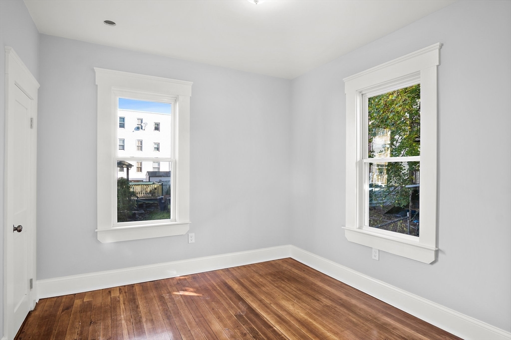 10 Sutton Street, Unit 3 Boston, MA 02126 - Photo 11 of 18 a view of an empty room with wooden floor and a window
