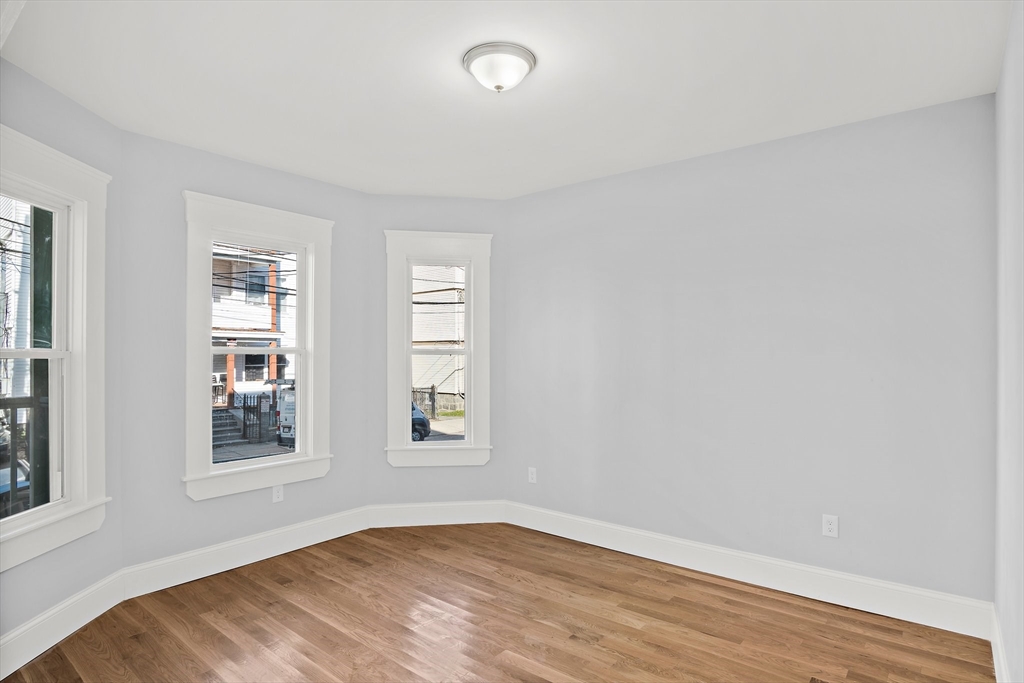 10 Sutton Street, Unit 3 Boston, MA 02126 - Photo 18 of 18 an empty room with wooden floor and windows