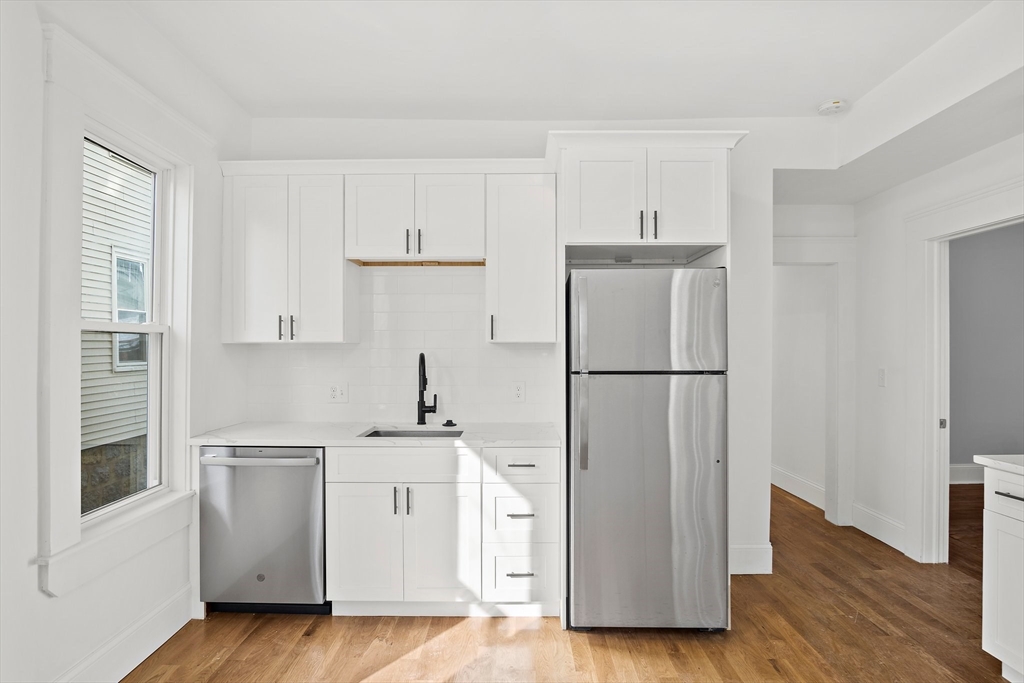 10 Sutton Street, Unit 3 Boston, MA 02126 - Photo 2 of 18 a kitchen with stainless steel appliances a refrigerator sink and cabinets