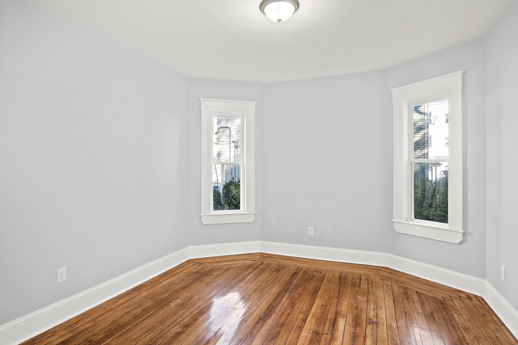 10 Sutton Street, Unit 3 Boston, MA 02126 - Photo 6 of 18 an empty room with wooden floor and windows
