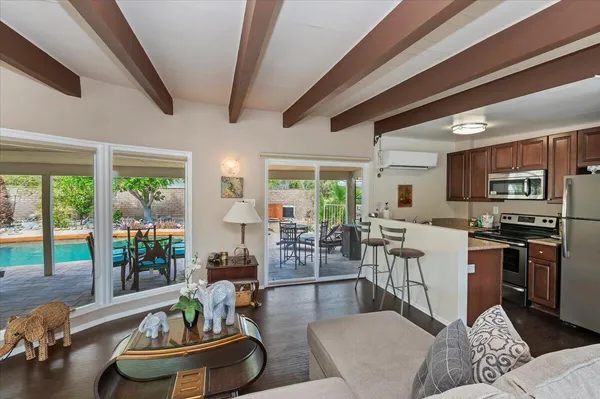 a living room with stainless steel appliances furniture and a large window