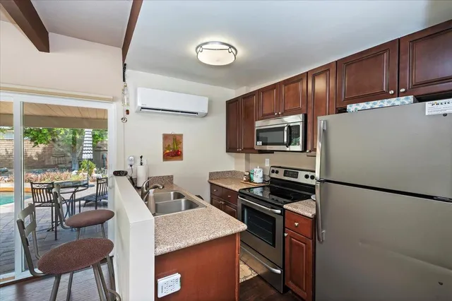 a kitchen with a refrigerator stove top oven dining table and chairs