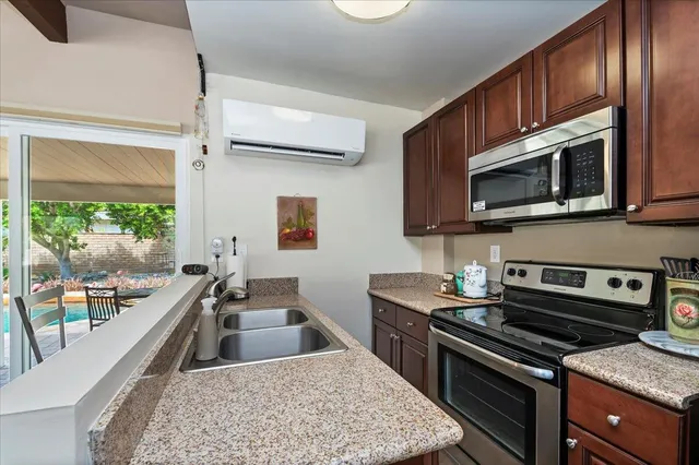 a kitchen with stainless steel appliances granite countertop a stove a sink and a microwave