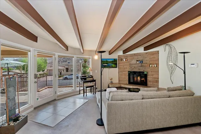 a living room with furniture a fireplace and a floor to ceiling window