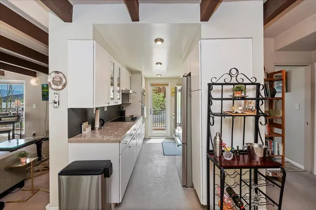 a living room with lots of furniture and kitchen view