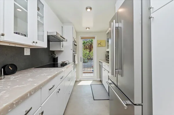 a kitchen with a table chairs refrigerator and cabinets