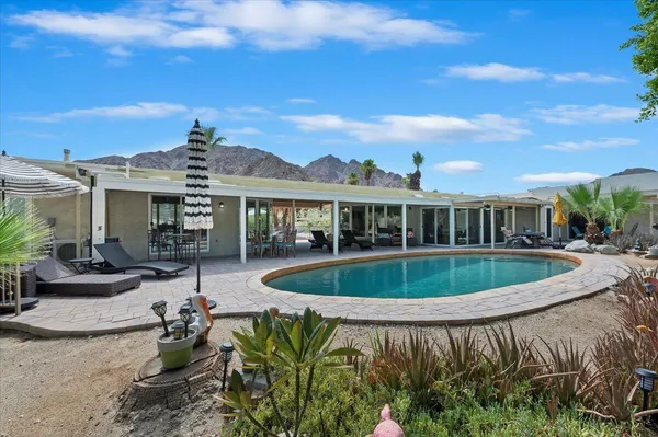 a view of a house with swimming pool and a yard