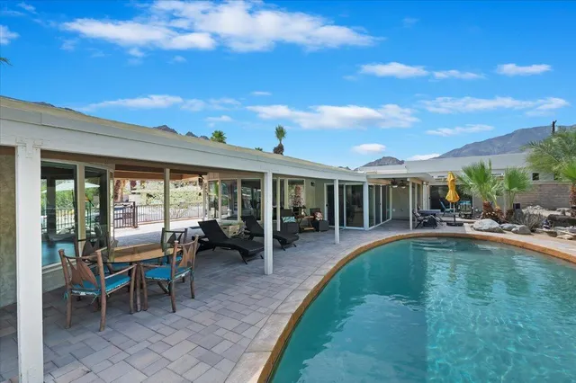 a front view of a house with swimming pool and porch
