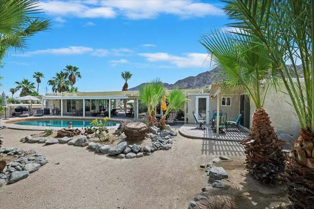 a view of a house with swimming pool and sitting area