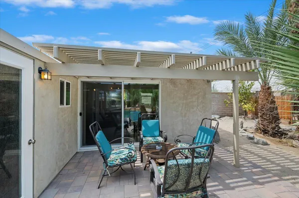 a view of a house with backyard and sitting area