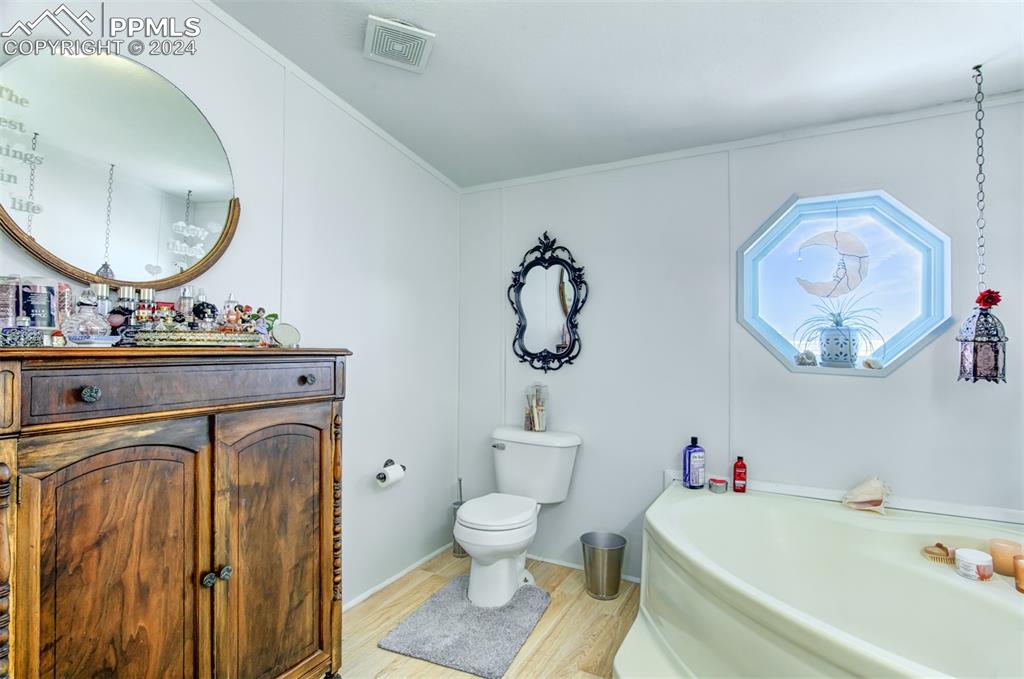 7270 South Yoder Road Yoder, CO 80864 - Photo 15 of 37 a bathroom with a toilet a sink and a mirror
