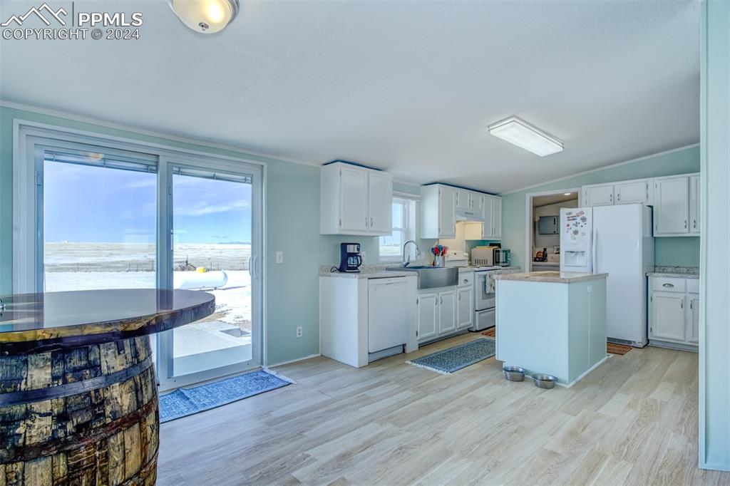7270 South Yoder Road Yoder, CO 80864 - Photo 7 of 37 a kitchen with cabinets and wooden floor