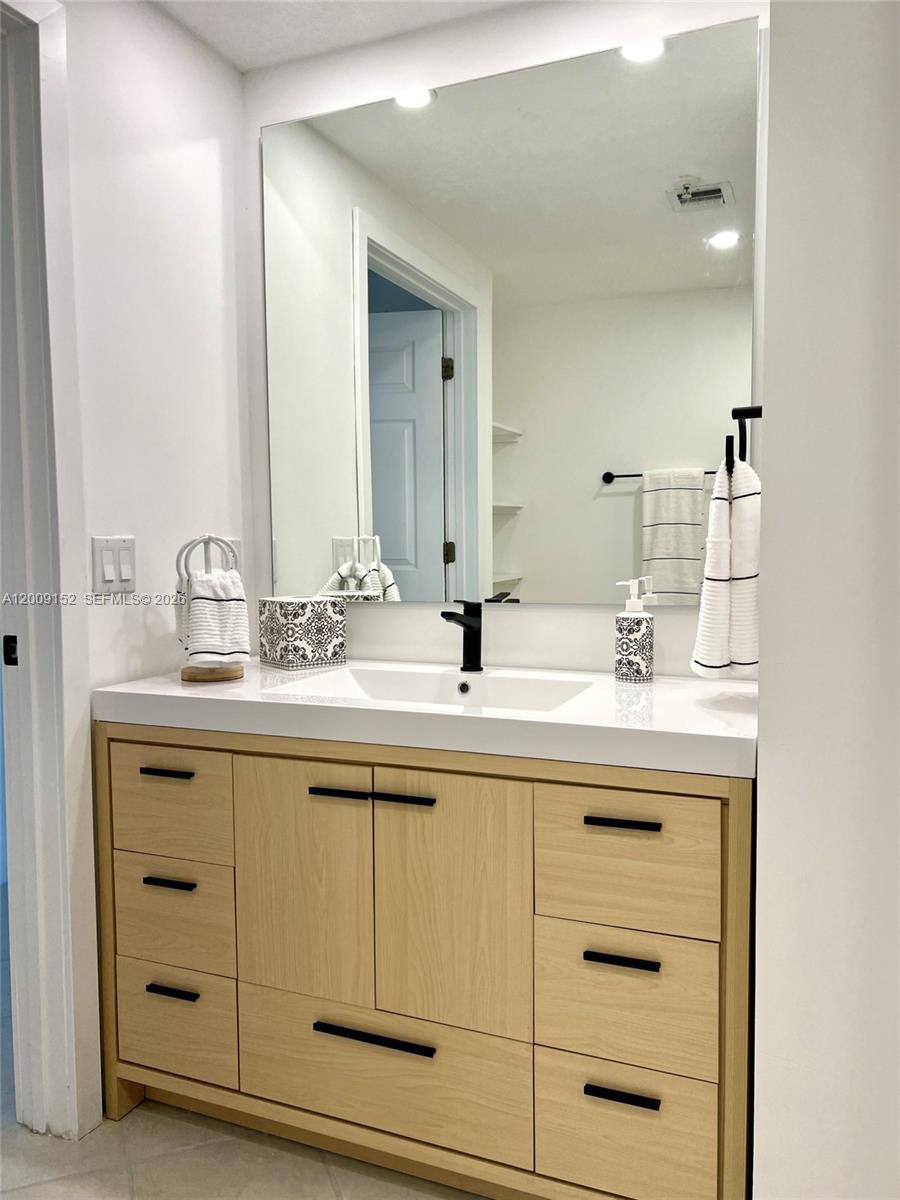 a bathroom with a sink vanity and a mirror