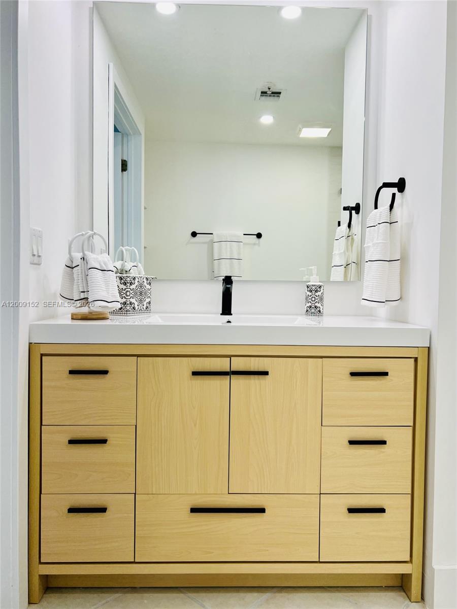 3500 Coral Way, Unit 1102 Miami, FL 33145 - Photo 3 of 8 a bathroom with a granite countertop sink and a mirror