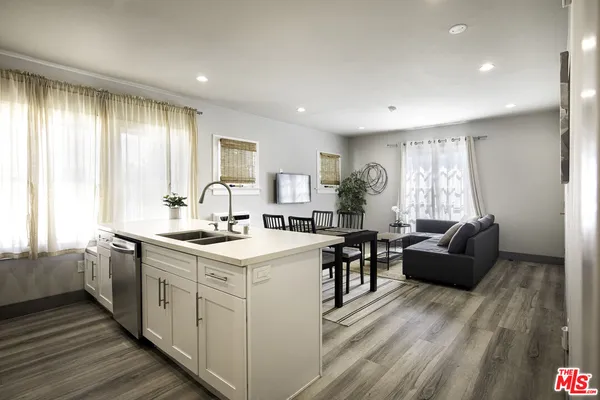 a kitchen with a dining table chairs and refrigerator