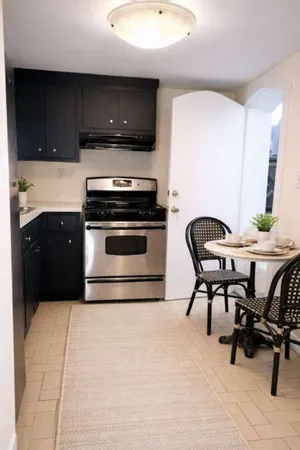 a kitchen with a table chairs a sink and a stove