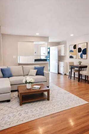 a living room with furniture and wooden floor