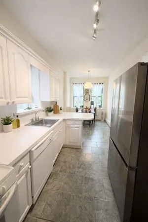 a kitchen with white cabinets and white appliances