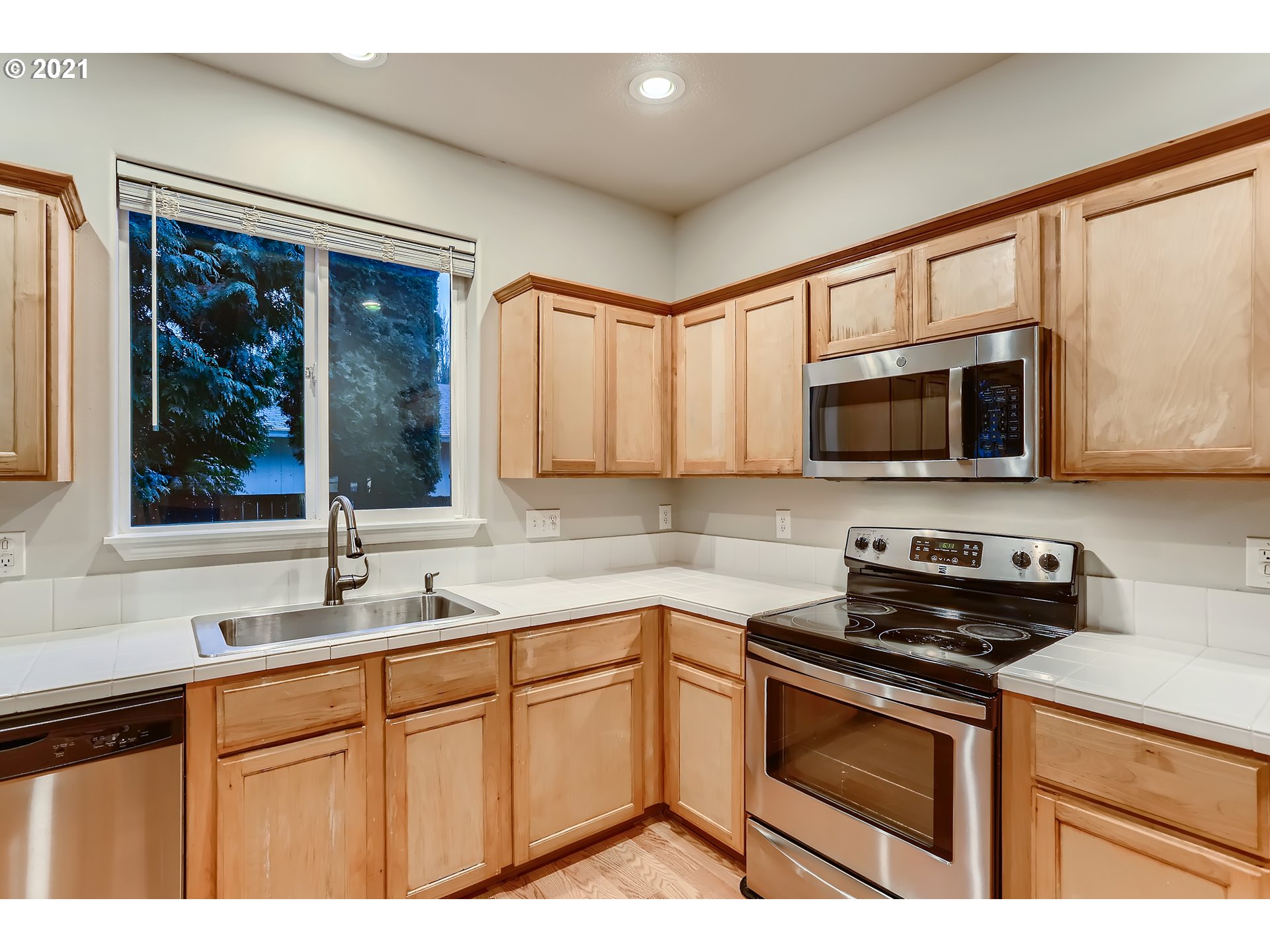 17670 Southwest September Lane Beaverton, OR 97003 - Photo 13 of 31 a kitchen with stainless steel appliances granite countertop a stove microwave and sink