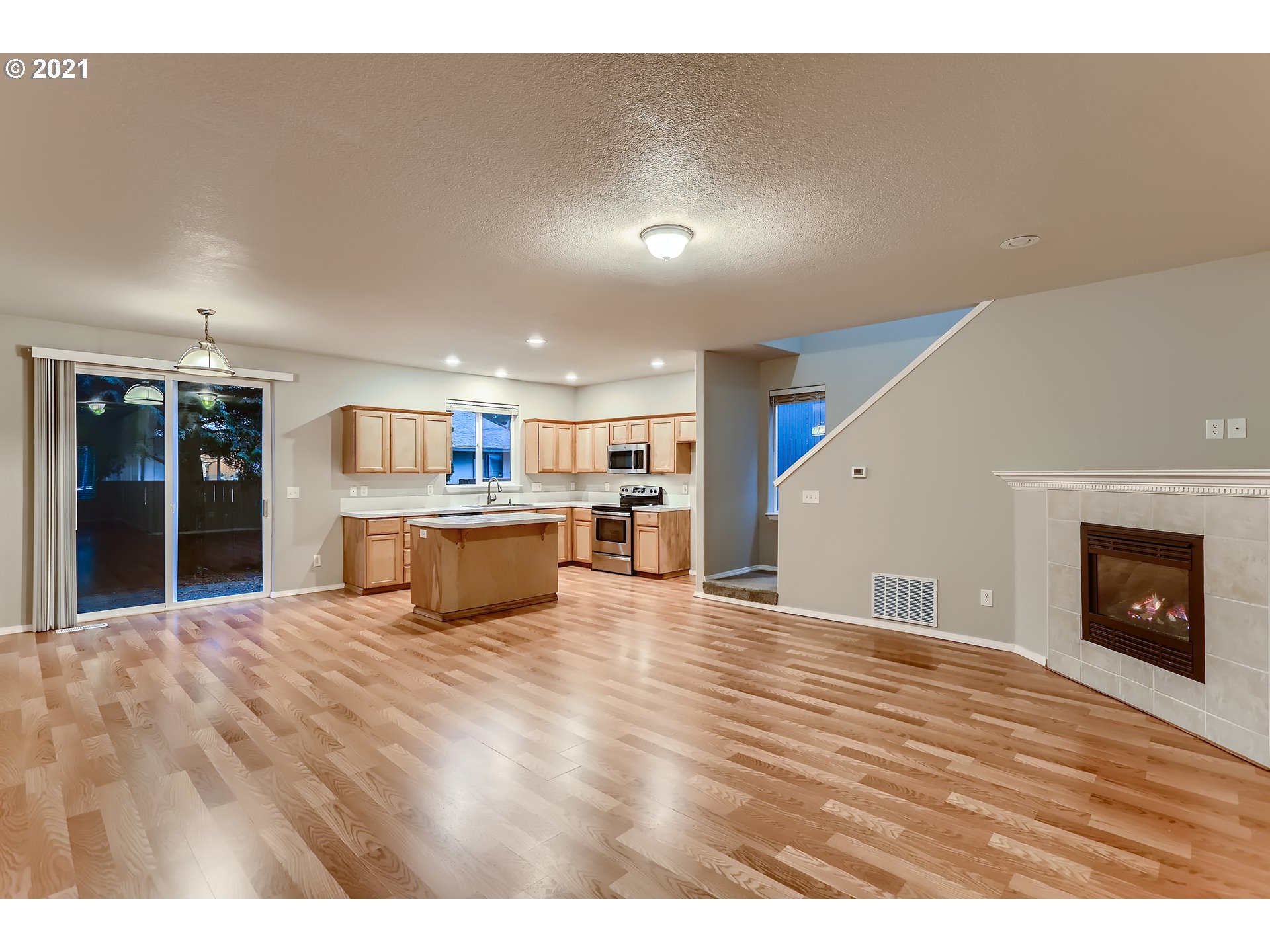 17670 Southwest September Lane Beaverton, OR 97003 - Photo 6 of 31 a view of a kitchen with kitchen island a sink wooden floor and a living room