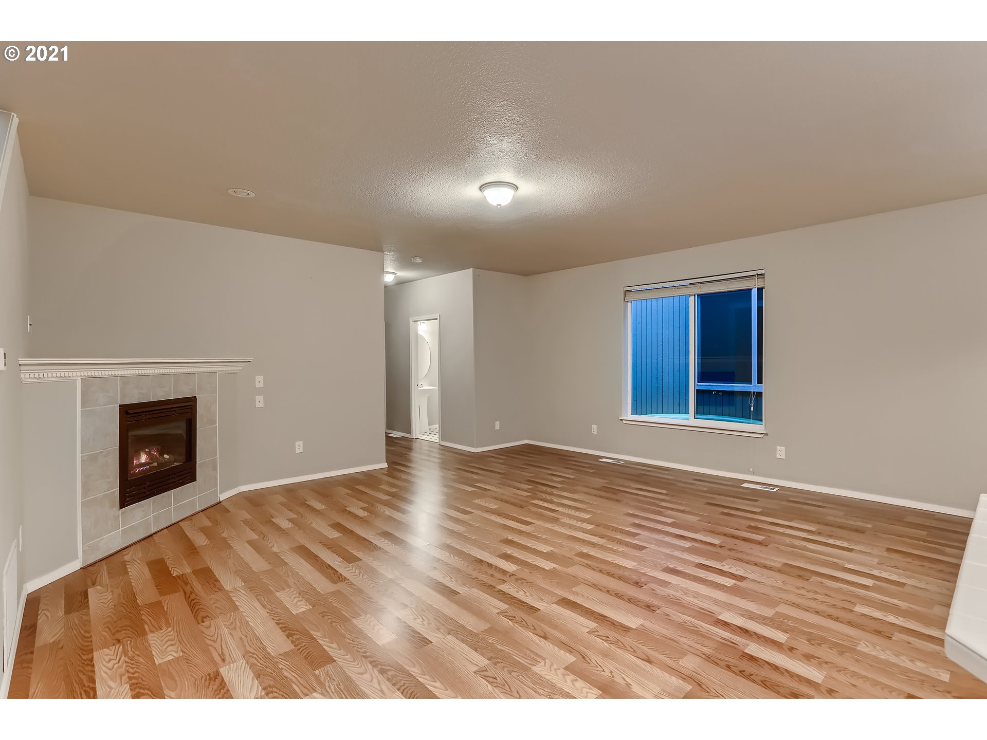 17670 Southwest September Lane Beaverton, OR 97003 - Photo 8 of 31 a view of an empty room with wooden floor fireplace and a window