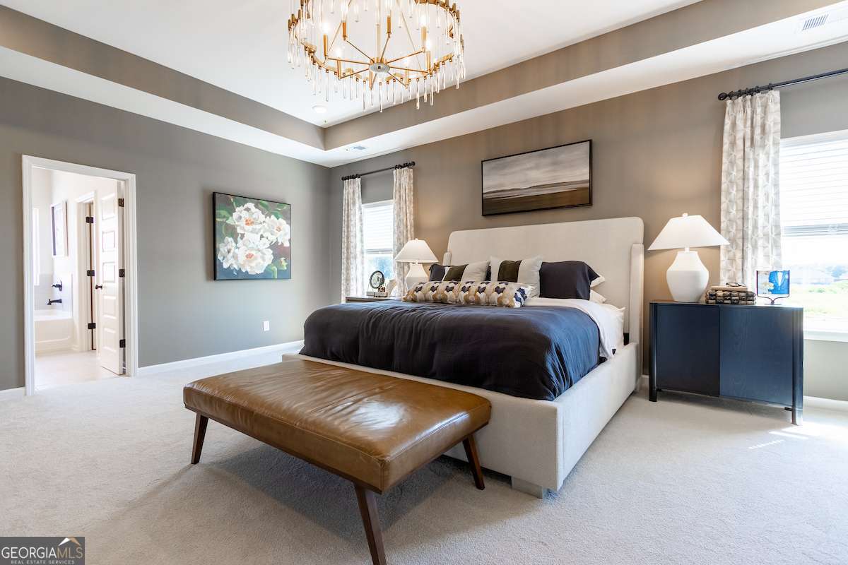 1422 Trellis Court, Unit (LOT 22) Hampton, GA 30228 - Photo 28 of 34 a spacious bedroom with a bed and a chandelier