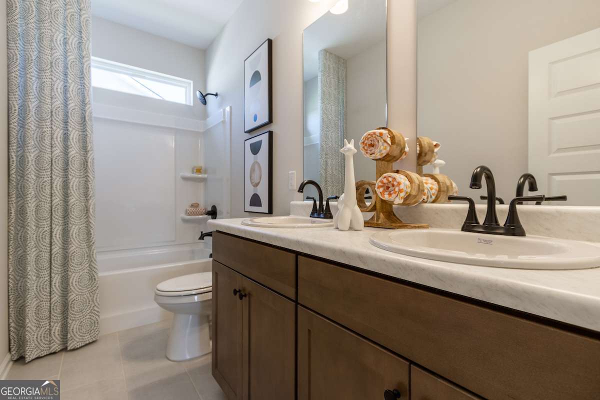 1422 Trellis Court, Unit (LOT 22) Hampton, GA 30228 - Photo 3 of 34 a bathroom with a double vanity sink toilet mirror and shower