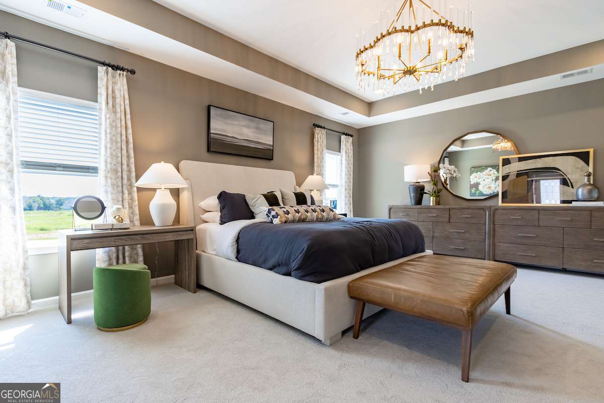 1422 Trellis Court, Unit (LOT 22) Hampton, GA 30228 - Photo 31 of 34 a spacious bedroom with a bed a chandelier and a dresser