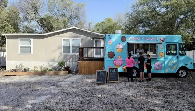 a view of a house with a yard and furniture