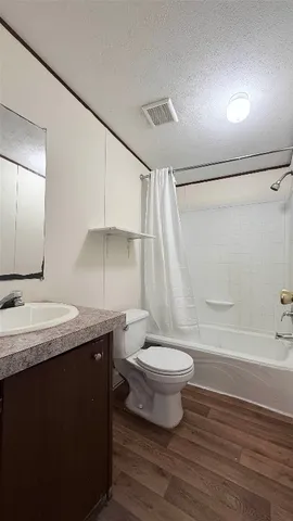 a bathroom with a granite countertop sink toilet a mirror and shower