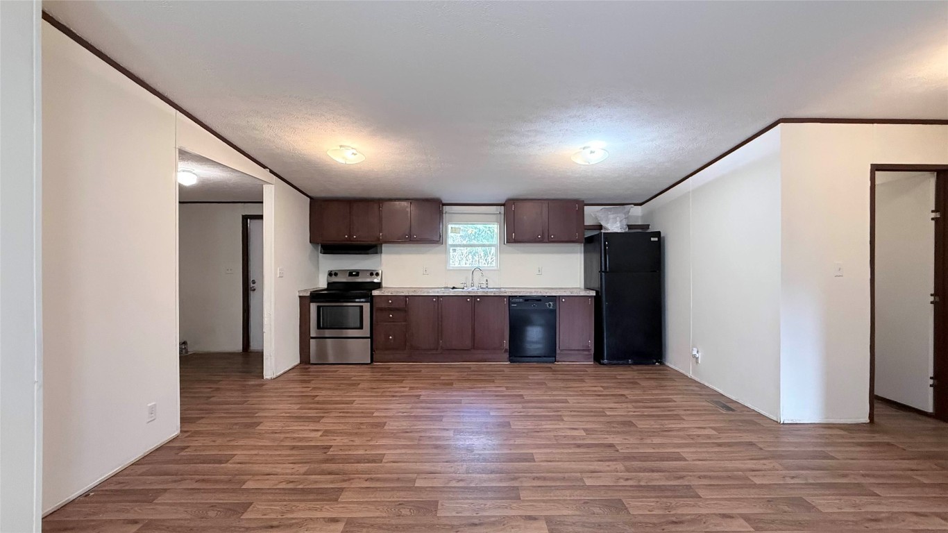 1430 West Howard Lane, Unit 4 Austin, TX 78728 - Photo 5 of 18 a kitchen with stainless steel appliances kitchen island granite countertop a refrigerator and a stove