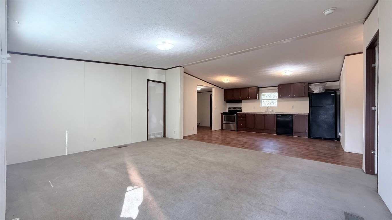 1430 West Howard Lane, Unit 4 Austin, TX 78728 - Photo 7 of 18 an empty room with a kitchen and a refrigerator