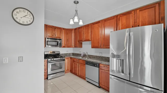 a kitchen with stainless steel appliances granite countertop a refrigerator a stove a sink and dishwasher