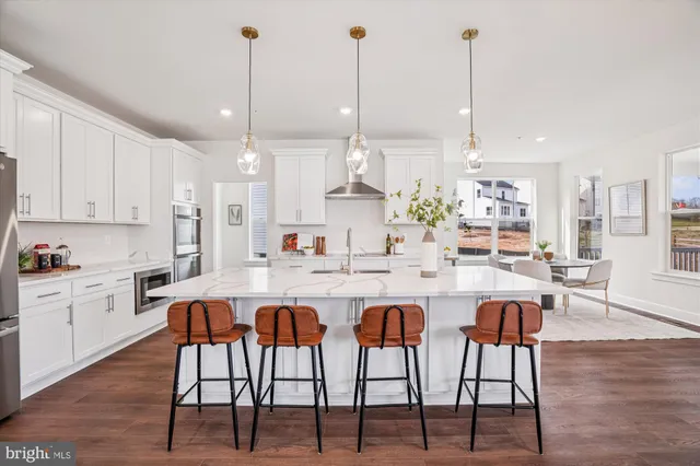 a kitchen with appliances cabinets and chair