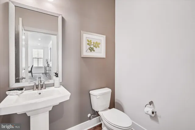 a bathroom with a toilet a sink and mirror