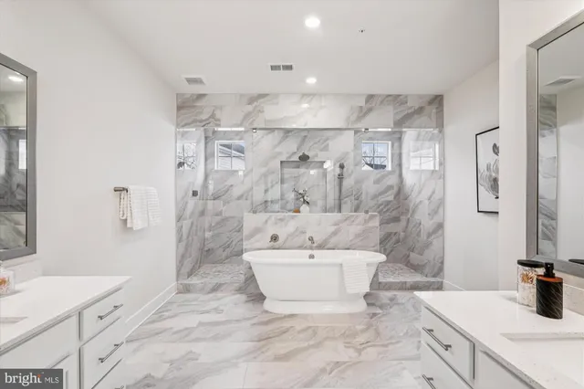 a bathroom with a tub sink and mirror