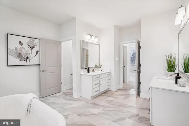 a spacious bathroom with a double vanity sink a large mirror a bathtub and shower