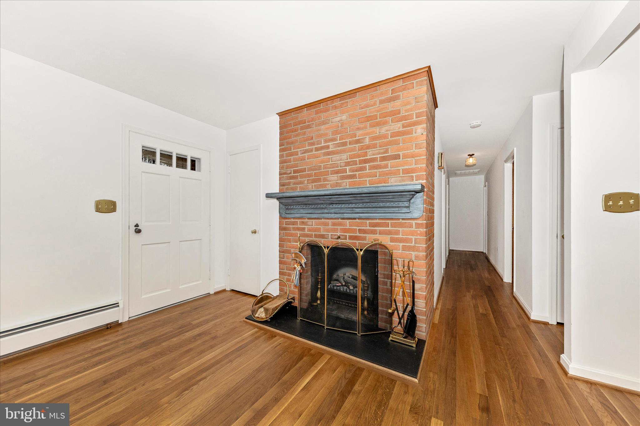 9811 Watkins Road Gaithersburg, MD 20882 - Photo 2 of 54 a view of a livingroom with wooden floor and a fireplace