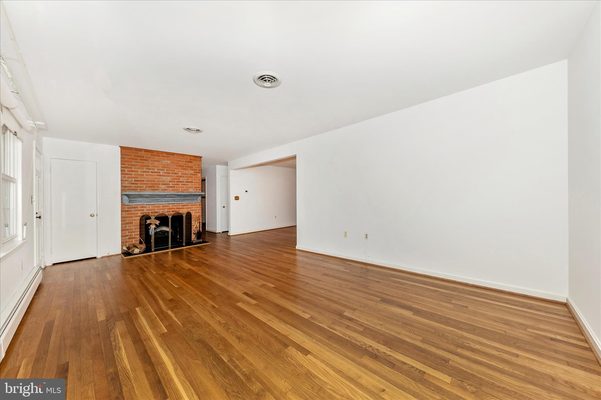 9811 Watkins Road Gaithersburg, MD 20882 - Photo 5 of 54 a view of an empty room with wooden floor and a window