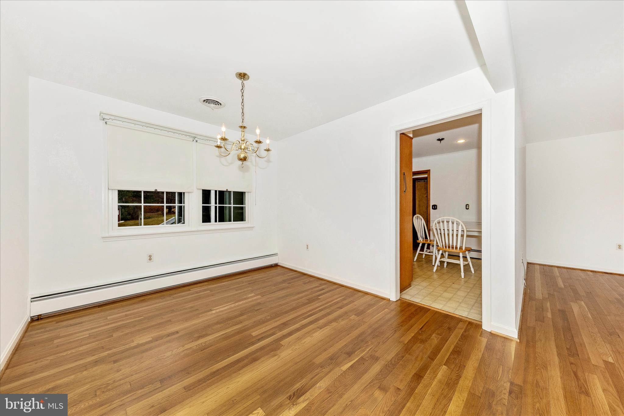 9811 Watkins Road Gaithersburg, MD 20882 - Photo 8 of 54 a view of a livingroom with wooden floor and a chandelier