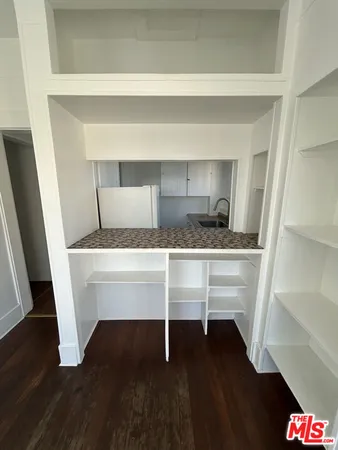 a hallway with table and white cabinet