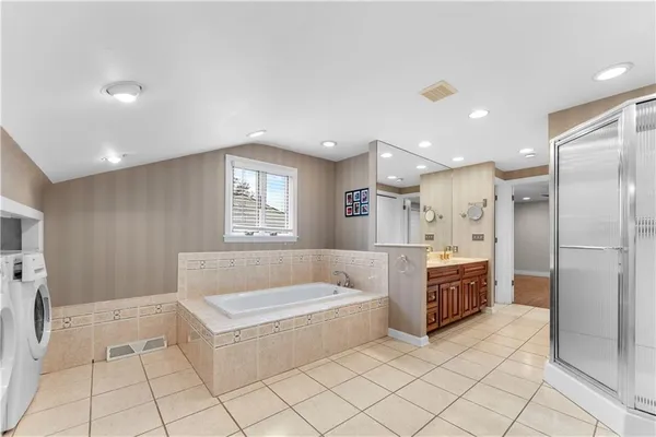 a bathroom with a tub a sink and a mirror