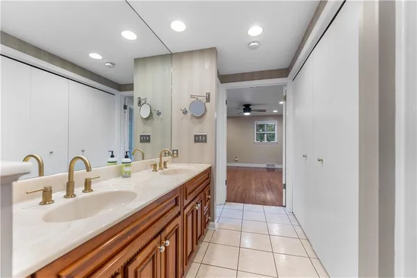 a spacious bathroom with a sink a shower and a mirror