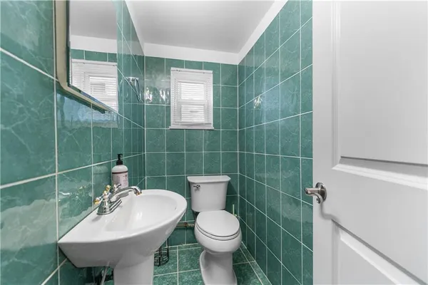 a bathroom with a sink toilet and a mirror