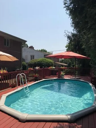 a view of swimming pool with deck and a yard