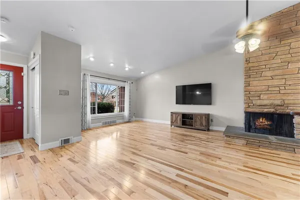 a view of a livingroom with wooden floor and a fireplace