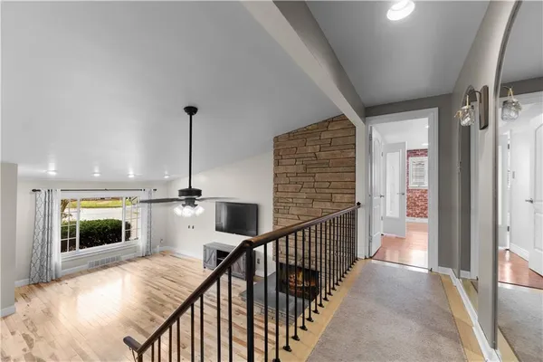a view of a hallway with wooden floor and staircase