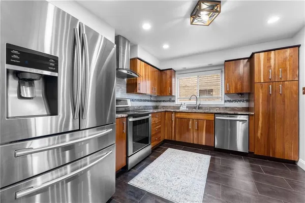 a kitchen with stainless steel appliances granite countertop a refrigerator stove and sink